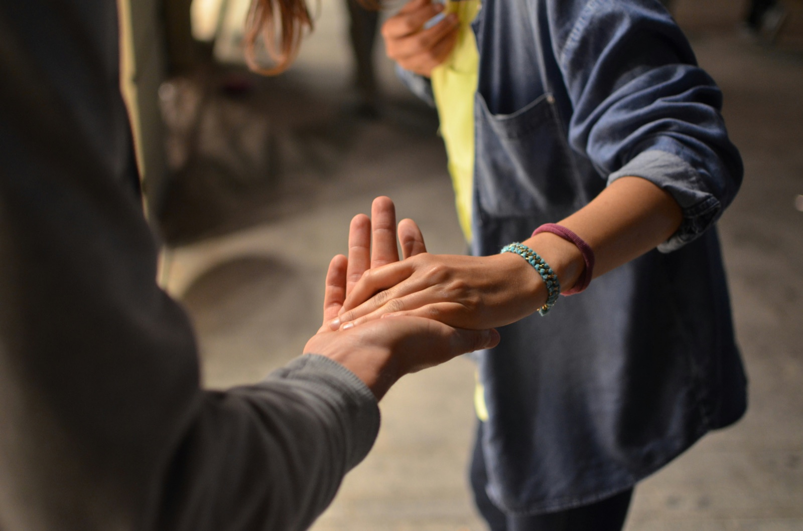 One person gently holding another's hand in comfort